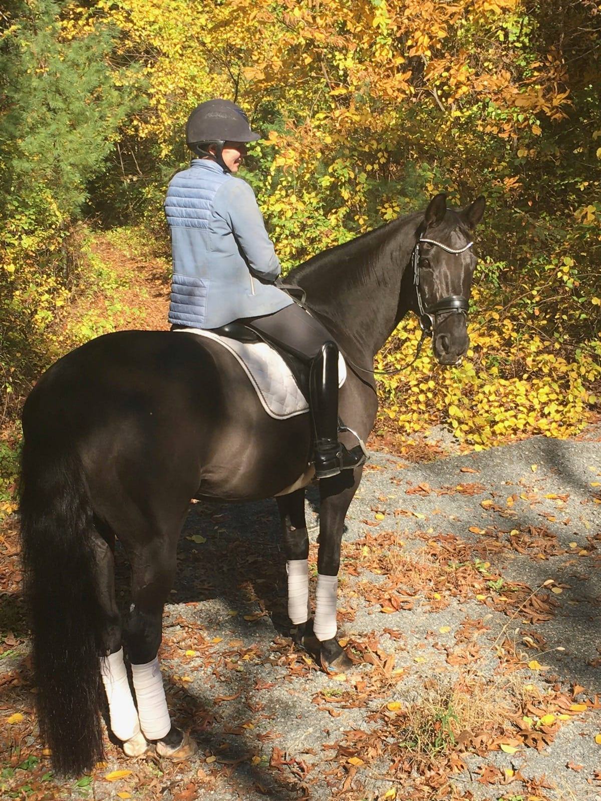 Hannah Maxner trail riding with her horse